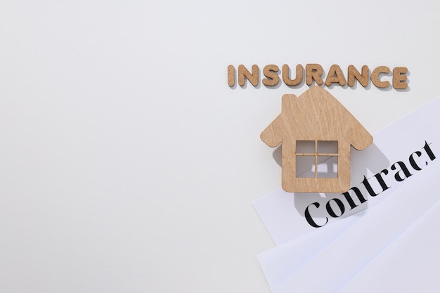 Wooden house words Insurance and Contract on white background space for text