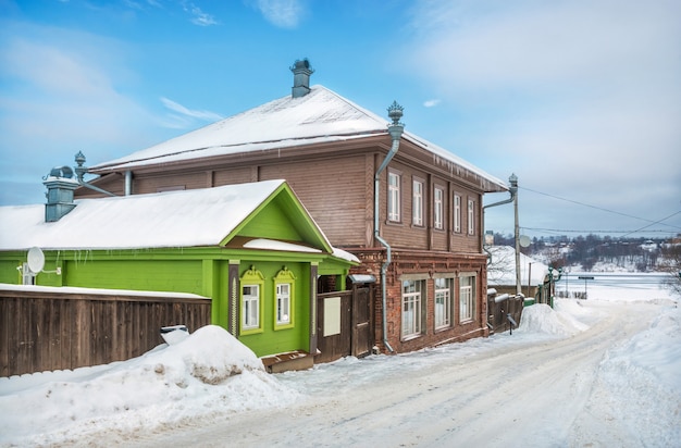 Wooden houses on Nikolskaya Street in Plyos in the light of a winter day under a blue sky