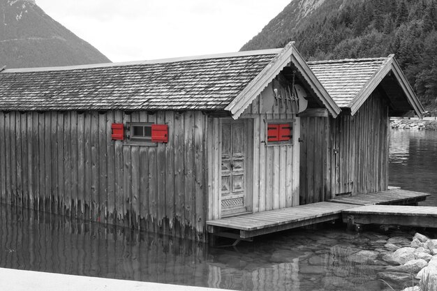 Foto case di legno sul fiume contro le montagne