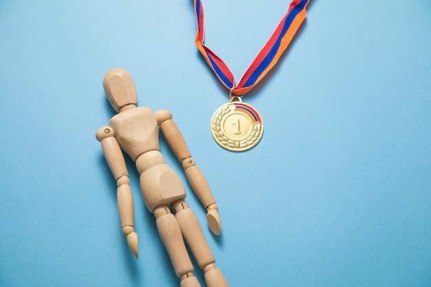 Foto figura umana in legno e medaglia per il vincitore