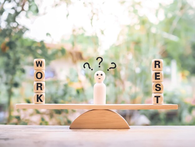 Wooden human figure with question marks The choice between work and rest