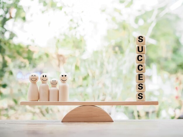 Wooden human figure and wooden blocks with the word SUCCESS on balancing scale for business success and winner concept