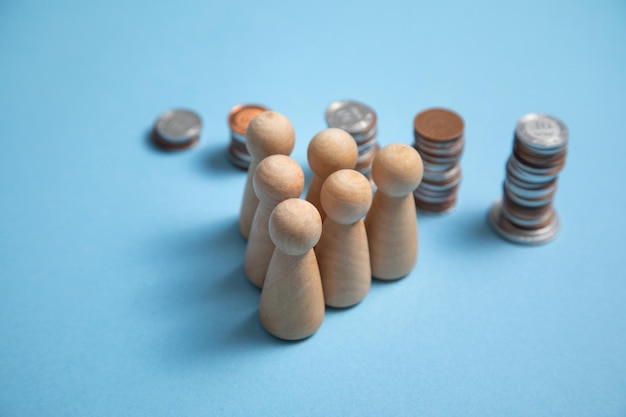 Wooden human figures with a stack of coins