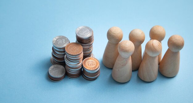 Wooden human figures with a stack of coins