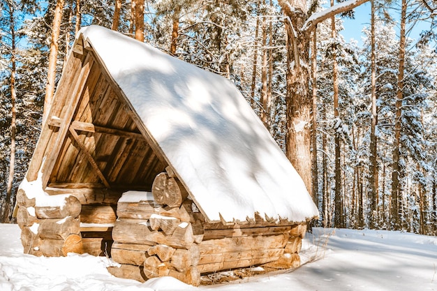 A wooden hut or a house in a snowy winter forest