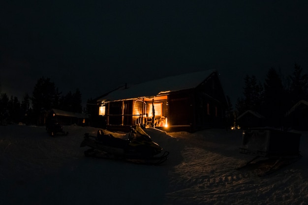 夜の雪の木製小屋