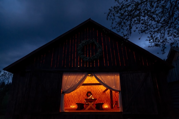 Деревянная хижина со столиком внутри, освещенным свечами, создающими уютную атмосферу, готовую для банкета прополки