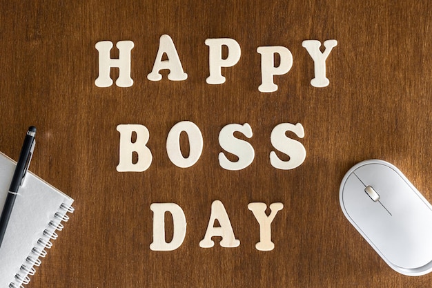 Wooden inscription happy boss day on a wooden background