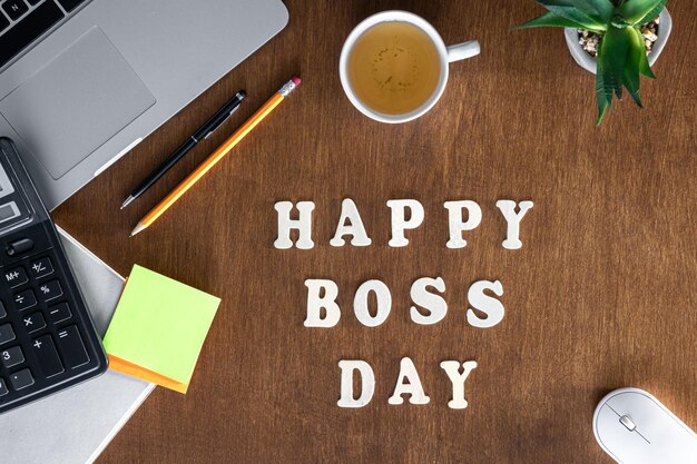 Photo wooden inscription happy boss day on a wooden office desk background