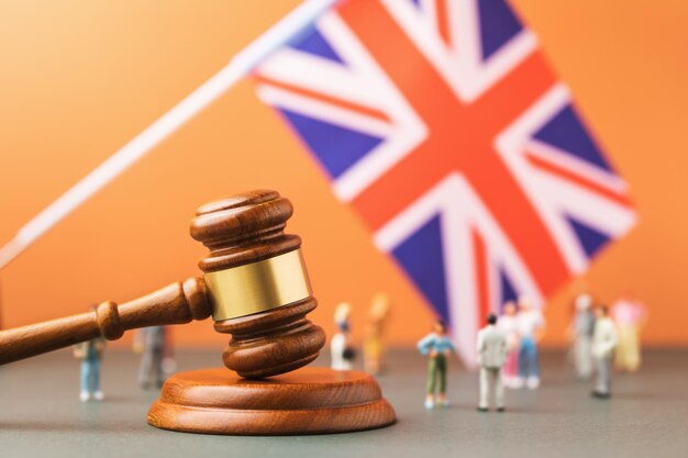 Wooden judge gavel flag and plastic toys the concept of trials in the British Society