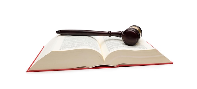 白い背景で隔離の開いた法律の本に木製の裁判官のガベル。ウェブサイトや雑誌のレイアウトに最適