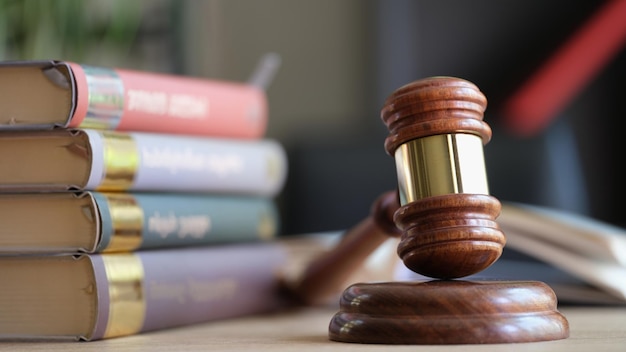 Wooden judge gavel and stack of legal book on table laws legal system and court concept