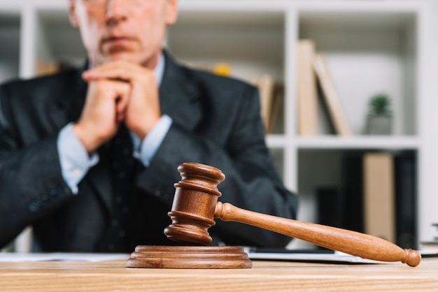 Photo wooden judge gavel on table in front of lawyer