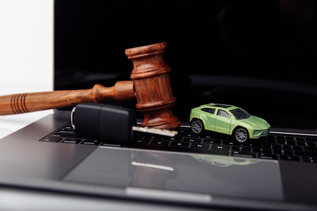 Wooden judge gavel with key and car auction and bidding concept