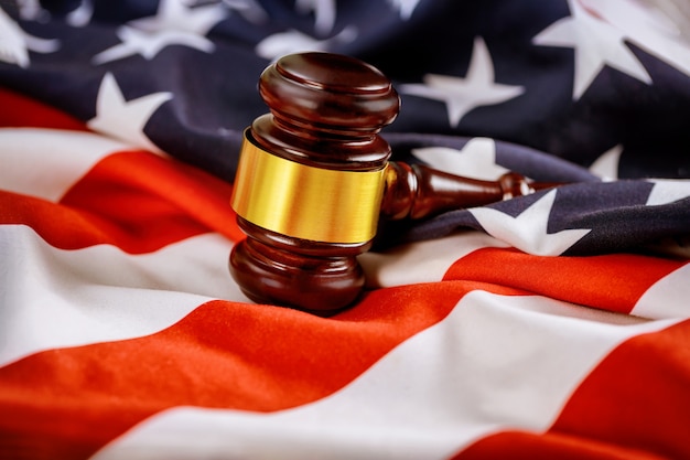 Wooden judge hammer on american flag Justice law