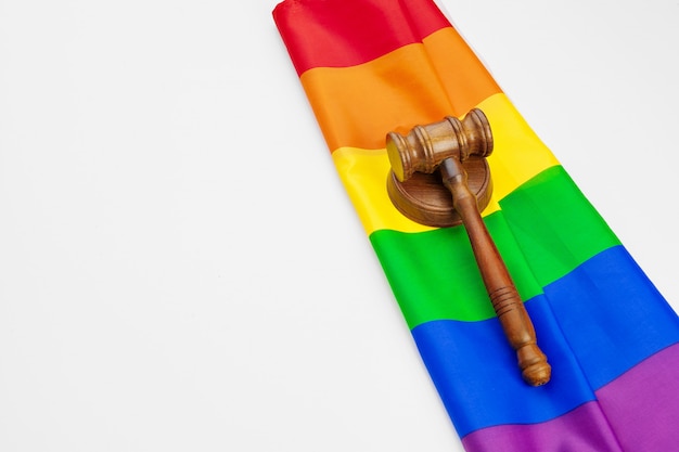 Wooden judge mallet and lgbt rainbow flag isolated. Law and lgbt