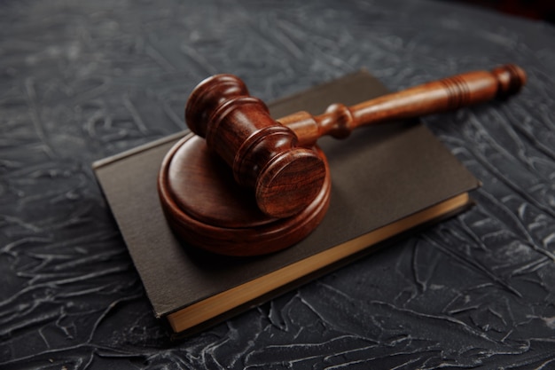 Wooden judges gavel lying on a law book in a courtroom for dispensing justice and sentencing crimes.