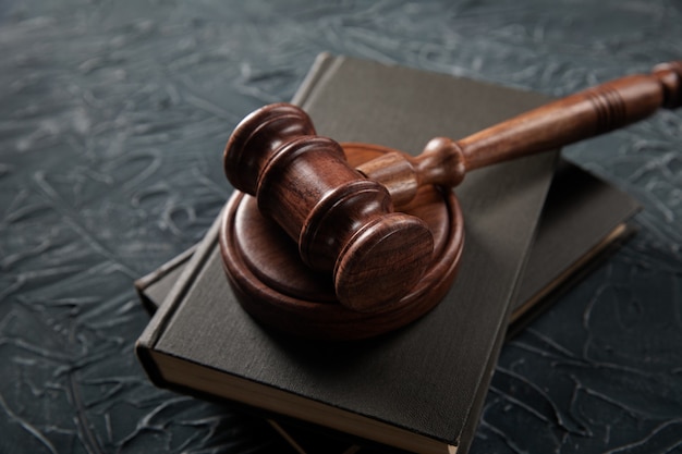 Wooden judges gavel lying on a law books in a courtroom for dispensing justice and sentencing crimes.