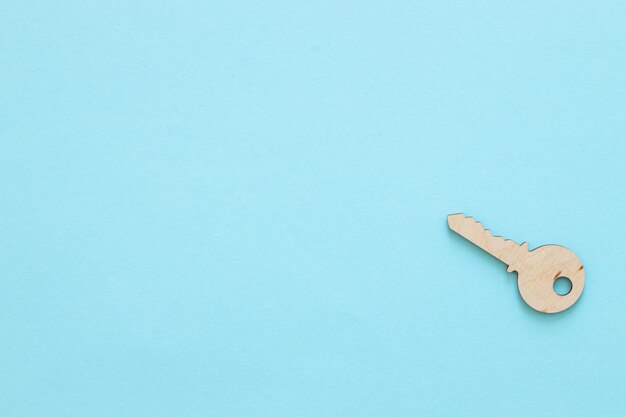 Wooden key on blue background buying new house real estate concept