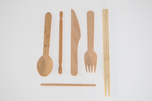 写真 白い背景に使い捨て食器用の木製ナイフ スプーン フォーク マドラーと中国の箸