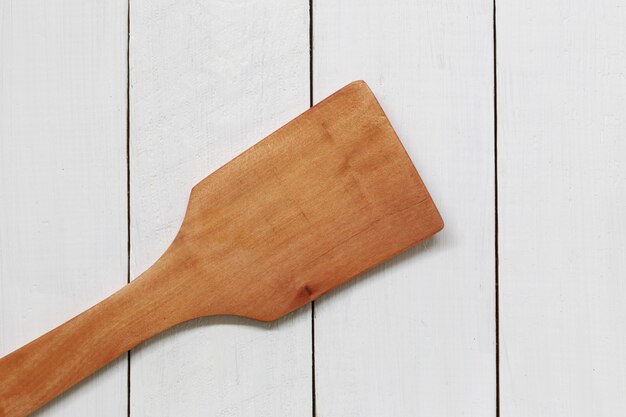 Photo wooden ladle for scoop on white wood.