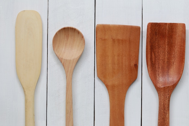 Wooden ladle for scoop on white wood.