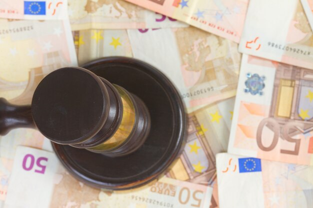 Деревянный молоток закона на фоне евро деньги, вид сверху