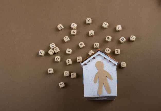 Wooden letter cubes and man figurine and model house