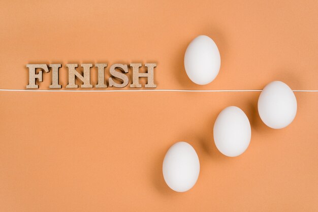 Wooden letters and eggs orange background