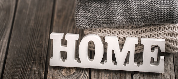 wooden letters with the inscription home and knitted sweaters