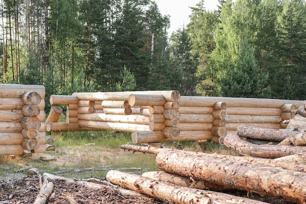 Wooden a log houses under construction with building materials lying nearby