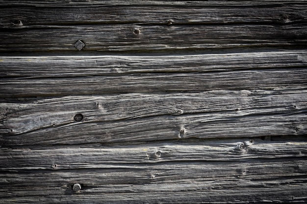 Wooden logs of an old house. Close-up. Weathered natural gray wood texture. Background. Horizontal photo. High quality photo
