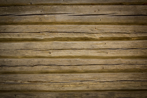 Wooden logs of an old house. Close-up. Weathered natural gray wood texture. Background. Horizontal photo. High quality photo