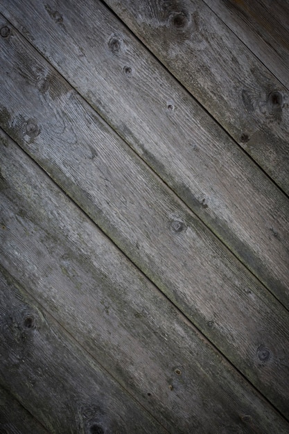 Wooden logs of an old house. Close-up. Weathered natural gray wood texture. Background. Horizontal vertical photo. High quality photo