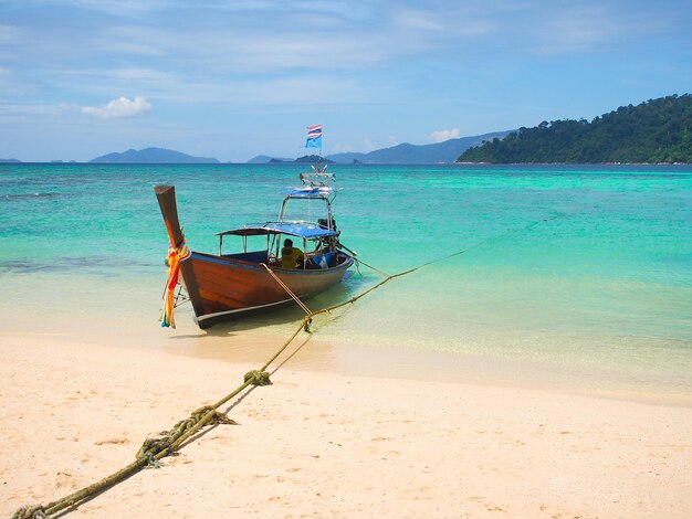 タイのリペ島で晴れた夏の日にターコイズブルーの海で木製のロングテールボート