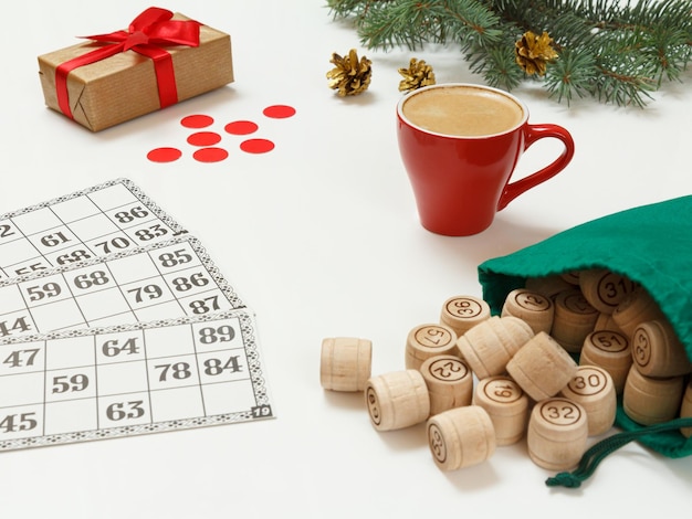 Wooden lotto barrels with bag game cards with cup of coffee and red chips for a game in lotto