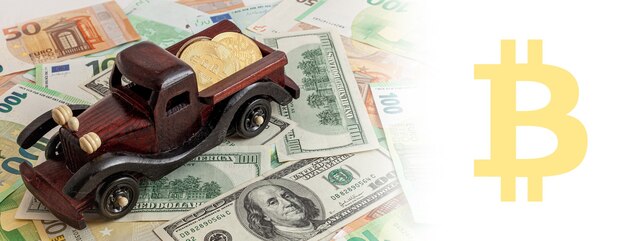 Деревянная машина с биткойнами на панораме фона текстуры евро и долларов