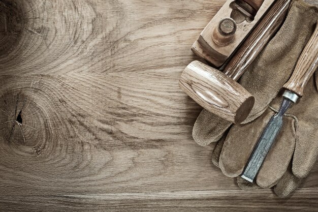 Wooden mallet shaving plane chisel protective gloves on wood board