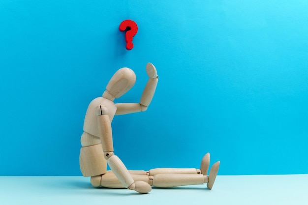 Wooden mannequin dummy figure and question mark confusion and asking question concept