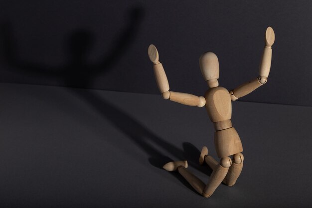 Photo wooden mannequin in imploration praying position on gray background religion concept copy space