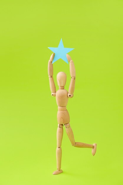 Wooden mannequin with star on color