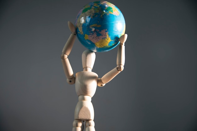 Photo wooden mannequin with world on his hand