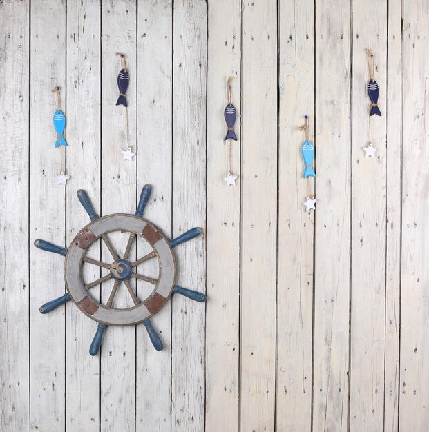 wooden marine steering wheel on white wooden background