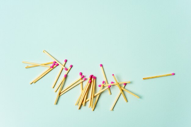 Photo wooden matches scattered on a turquoise pastel color background