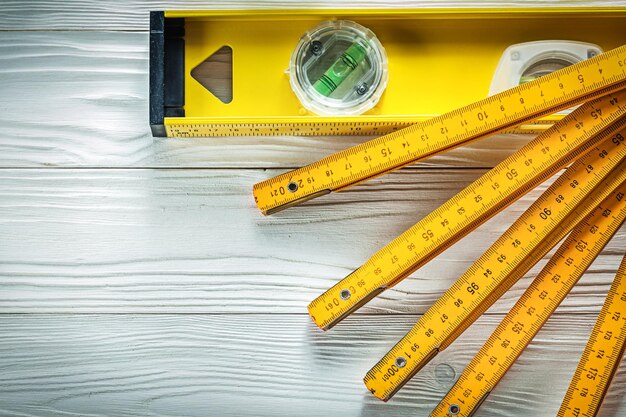 Photo wooden meter construction level on white board top view