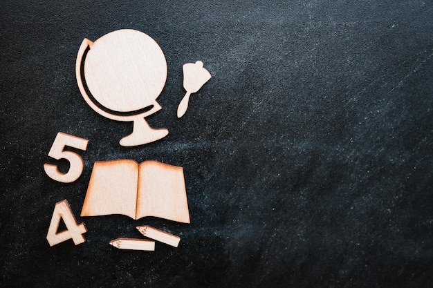 Wooden mockup of school supplies and drawings on the blackboard lying in an even layer