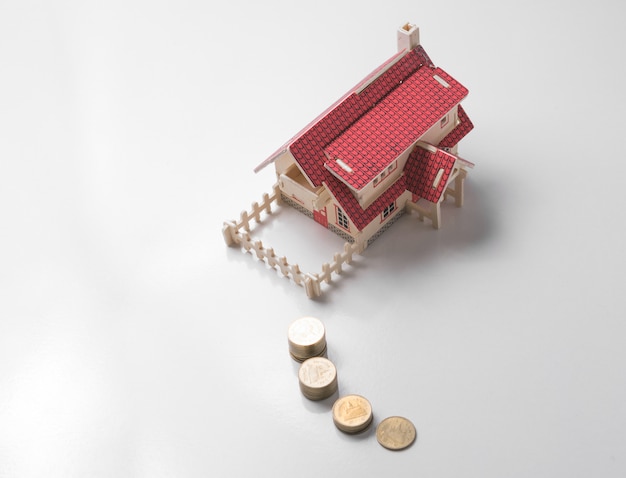 Photo wooden model house with money on white table