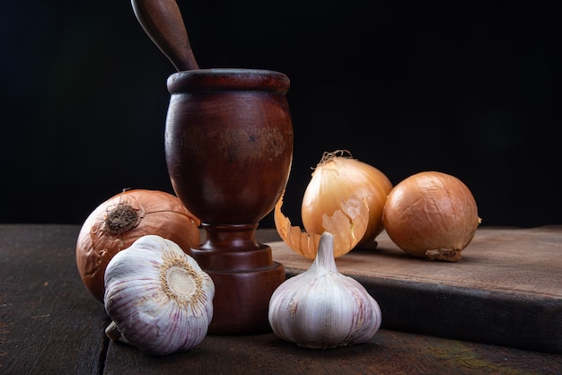 Wooden mortar and spices in a rustic arrangement on wood.