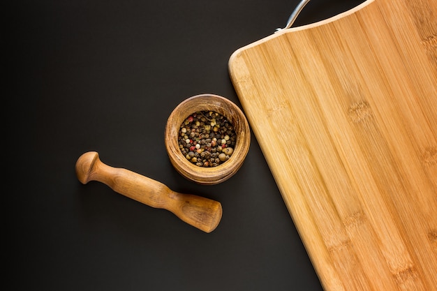 Photo wooden mortar with various spices and empty cutting board