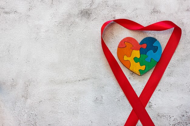 Деревянная разноцветная головоломка в форме сердца на сером фоне. День Святого Валентина концепции, отношения. Место для текста
